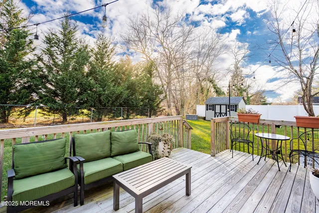 a balcony with wooden floor and outdoor seating