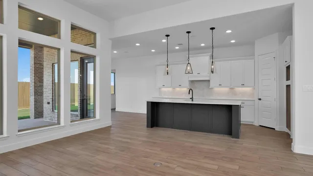 a kitchen with kitchen island a sink and a stove top oven