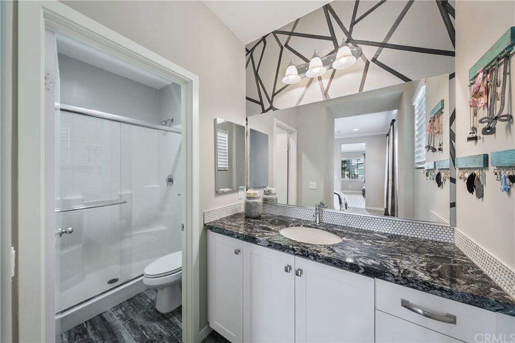 35162 Ladybug Lane Murrieta, CA 92563 - Photo 37 of 58 a bathroom with a granite countertop sink a toilet and shower