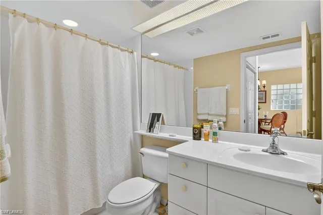 a bathroom with a double vanity sink toilet and mirror