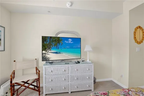 a living room with stainless steel appliances cabinets and flat screen tv