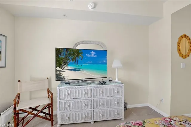 a living room with stainless steel appliances cabinets and flat screen tv