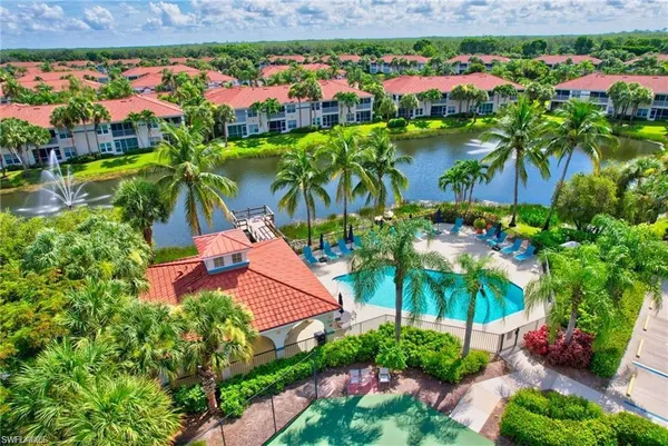 a view of a swimming pool with a yard and palm trees