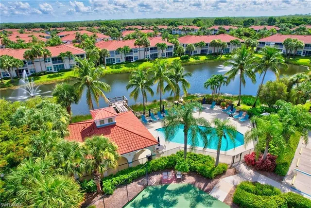 a view of a swimming pool with a yard and palm trees