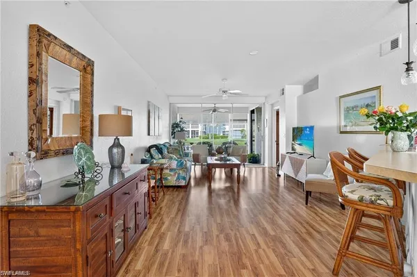 a living room with furniture wooden floor and a large window