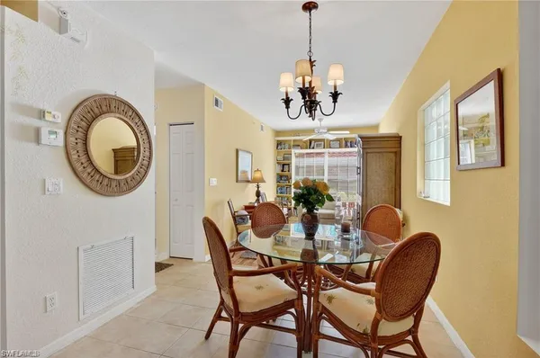 a dining room with furniture a chandelier and wooden floor