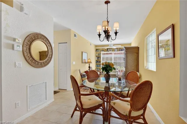 a dining room with furniture a chandelier and wooden floor