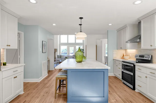a kitchen with kitchen island white cabinets and stainless steel appliances