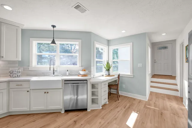 a kitchen with a sink cabinets and wooden floor