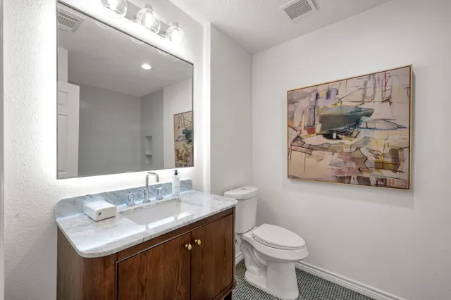 a bathroom with a sink vanity and toilet