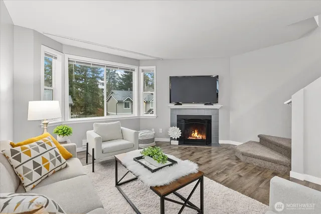 a living room with furniture a flat screen tv and a fireplace
