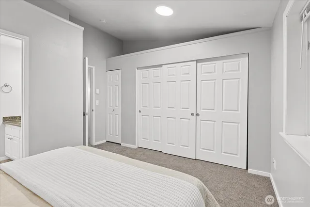 a bedroom with a bed and a painting on the wall