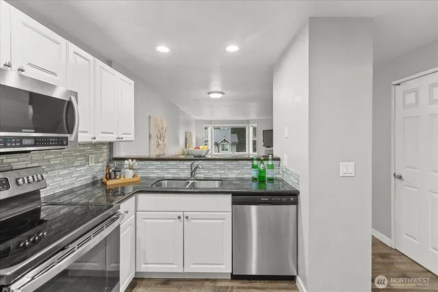 a kitchen with stainless steel appliances a refrigerator sink and microwave