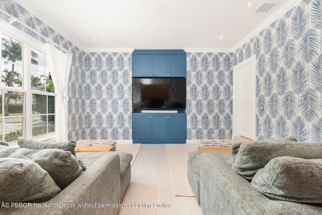 a living room with a couch a flat screen tv and a floor to ceiling window