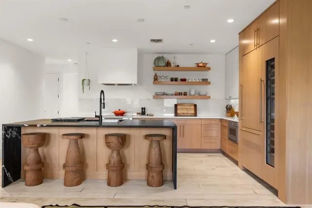 a living room with furniture large window and wall paintings
