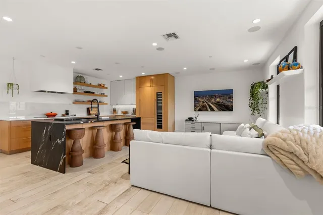 a living room with furniture wooden floor and a large window