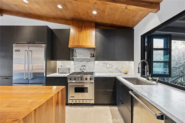 a kitchen with stainless steel appliances granite countertop a sink a stove and a refrigerator