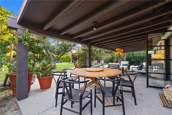 a view of a patio with chairs and potted plants