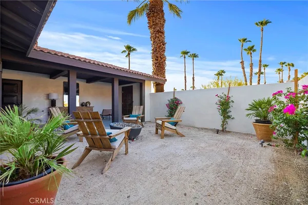 a view of a patio with table and chairs potted plants