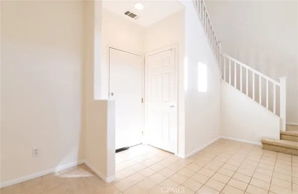 a view of a hallway with white walls and chandelier