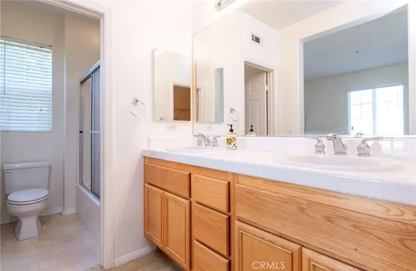 a bathroom with a granite countertop sink a toilet and a mirror