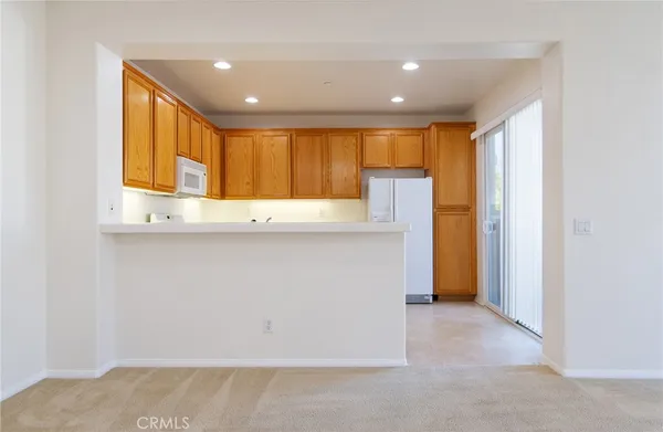 a view of a kitchen with a refrigerator and a sink