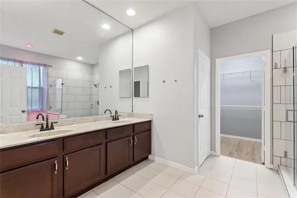 a bathroom with a double vanity sink mirror and shower