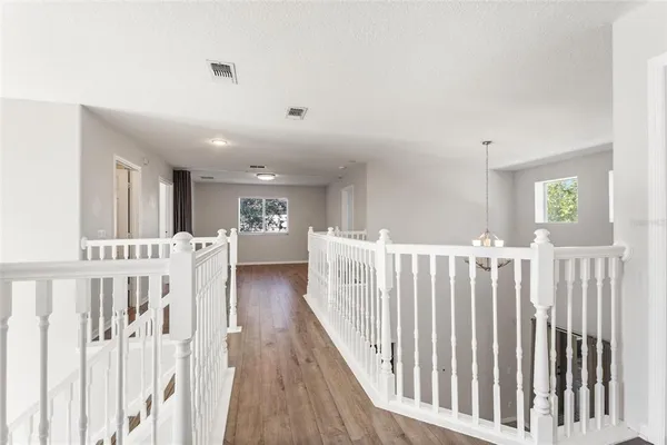 a view of a hallway with wooden floor and entryway