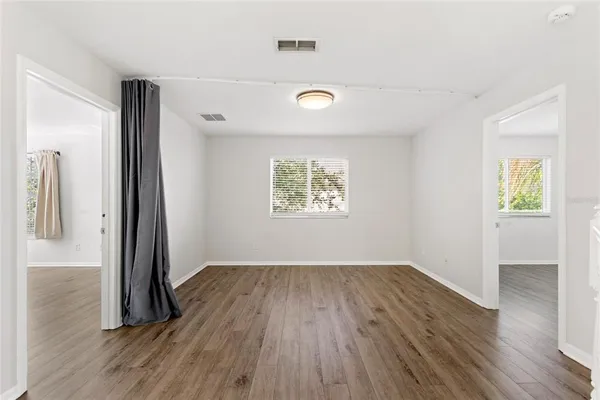 an empty room with wooden floor and a window