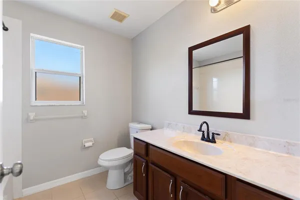 a bathroom with a toilet sink a mirror and vanity