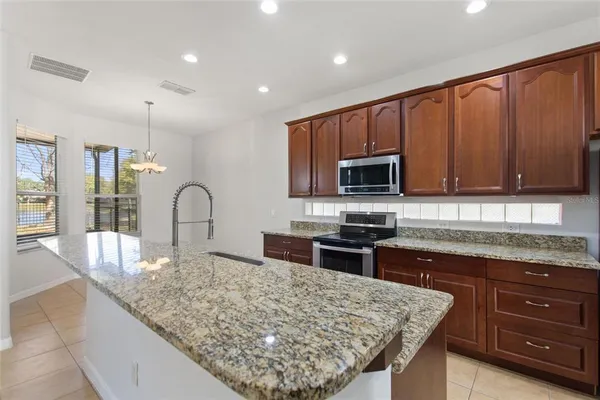 a kitchen with granite countertop wooden cabinets and stainless steel appliances
