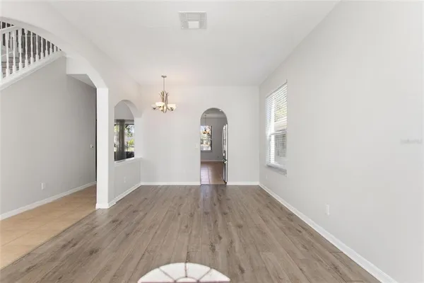 a view of a room with wooden floor staircase and a living room