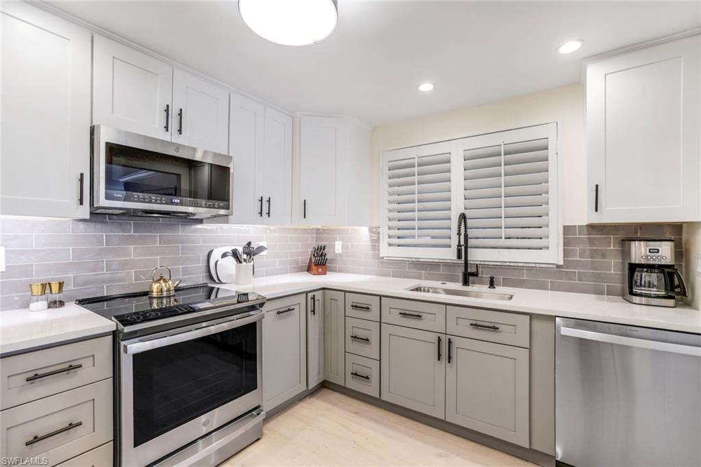 4150 Crayton Road, Unit B2 Naples, FL 34103 - Photo 4 of 23 a kitchen with a sink stove and microwave