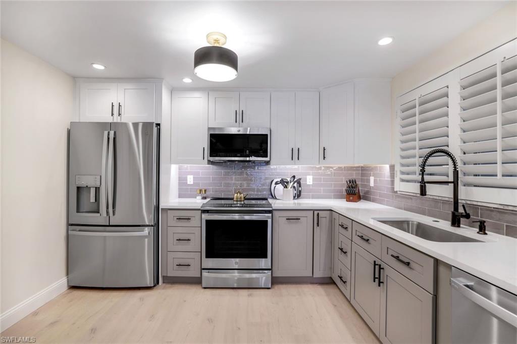 4150 Crayton Road, Unit B2 Naples, FL 34103 - Photo 5 of 23 a kitchen with a sink stainless steel appliances and cabinets