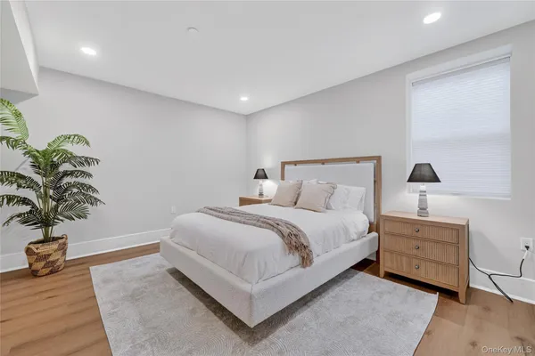 a spacious bedroom with a bed and a potted plant