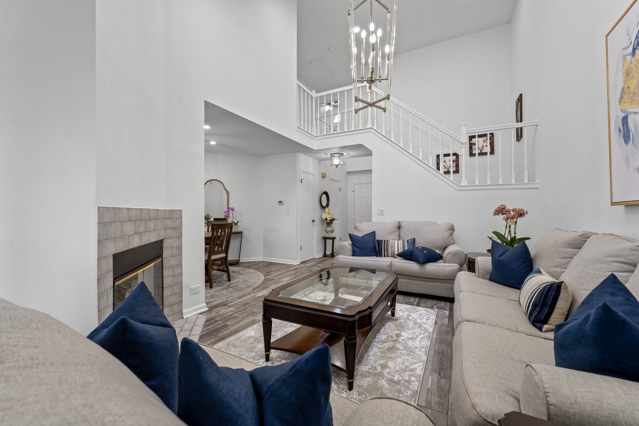 706 Brandon Place Wheeling, IL 60090 - Photo 12 of 42 a living room with furniture a fireplace and chandelier