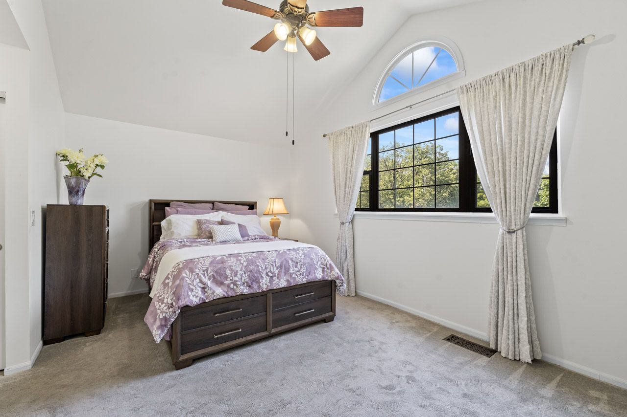 706 Brandon Place Wheeling, IL 60090 - Photo 31 of 42 a bedroom with a bed and a chandelier