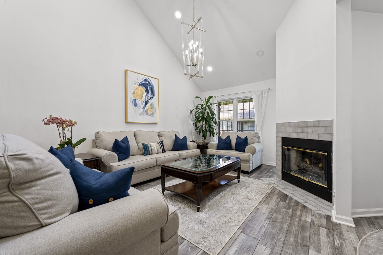 706 Brandon Place Wheeling, IL 60090 - Photo 10 of 42 a living room with furniture a chandelier and a fireplace