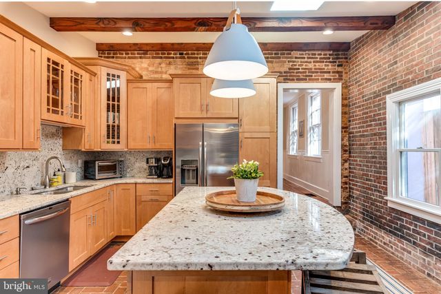 a spacious bathroom with a granite countertop sink a toilet and a mirror