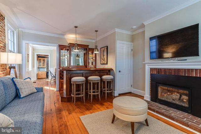 a living room with furniture a wooden floor and chandelier
