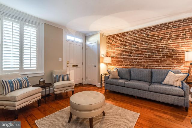 a dining room with wooden floor and chandelier