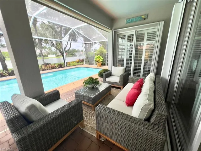 a living room with furniture and floor to ceiling windows