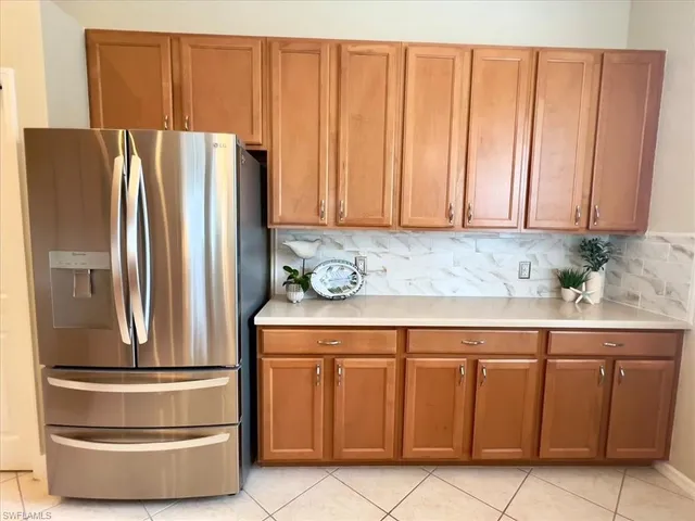 a kitchen with granite countertop a refrigerator a stove and a cabinets