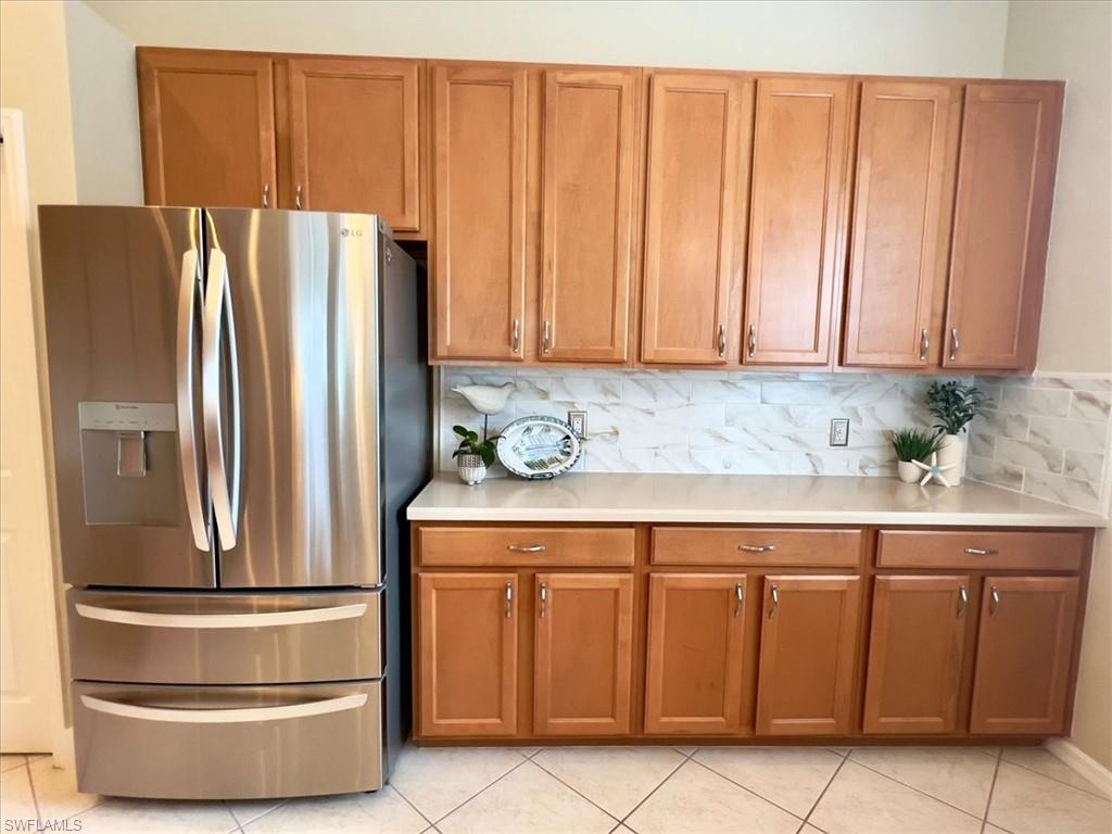 14291 Manchester Drive Naples, FL 34114 - Photo 19 of 49 a kitchen with granite countertop a refrigerator a stove and a cabinets