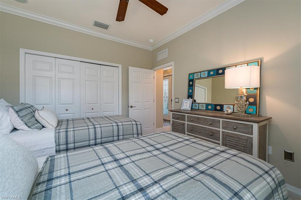 14291 Manchester Drive Naples, FL 34114 - Photo 31 of 49 a bedroom with a bed and a dresser in it