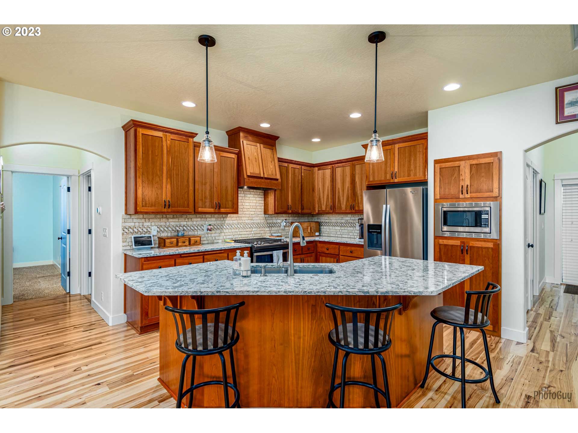 975 Riverstone Lane Springfield, OR 97477 - Photo 11 of 27 a kitchen with stainless steel appliances granite countertop a kitchen island a cabinets and wooden floor