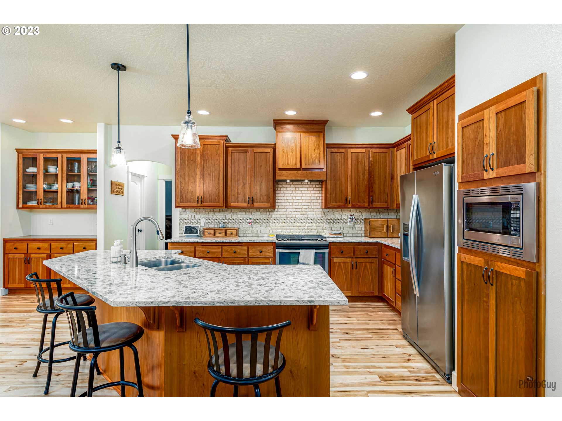 975 Riverstone Lane Springfield, OR 97477 - Photo 9 of 27 a kitchen with stainless steel appliances granite countertop a kitchen island a cabinets a refrigerator and a sink