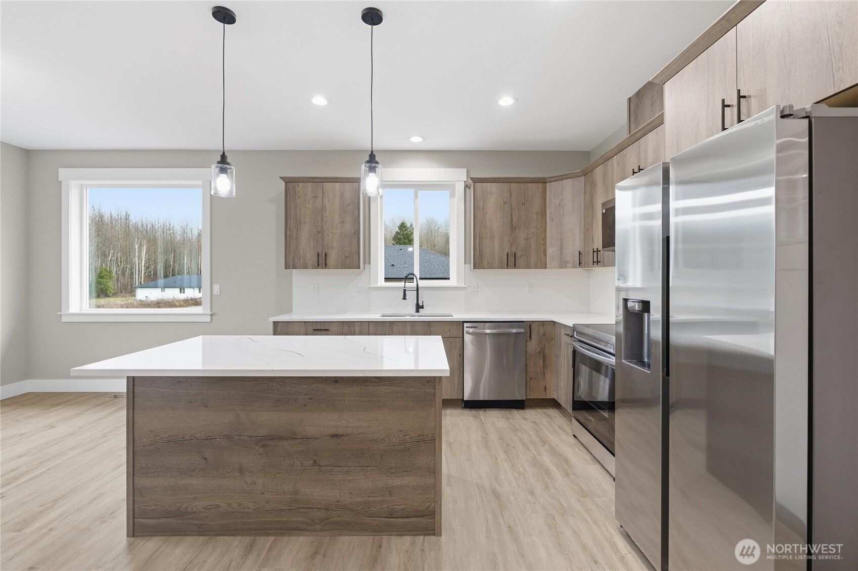 6473 Watson Loop Maple Falls, WA 98266 - Photo 6 of 25 a large kitchen with kitchen island a large counter top a sink stainless steel appliances and a window