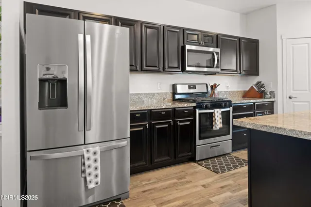 a kitchen with stainless steel appliances granite countertop a refrigerator stove and microwave