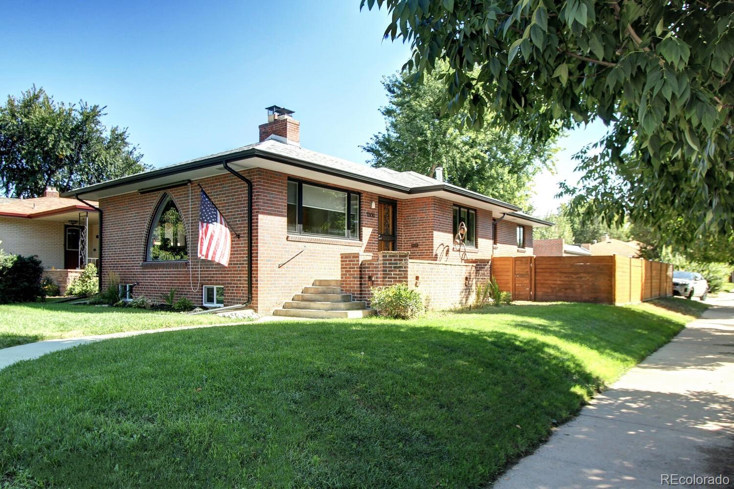 a front view of a house with a yard and trees